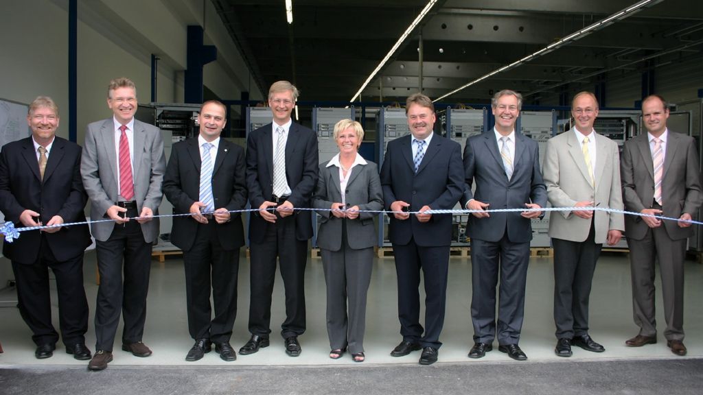Vor dem Durchschneiden des symbolischen Bandes (v.l.): Bereichsleiter Michael Vondermaßen, Bereichsleiter Jürgen Nies, Werkleiter Johann Kraus, Bereichsleiter Dr. Dirk-Eric Löbermann, Bürgermeisterin Rita Röhrl, MdL Helmut Brunner, Landrat Heinz Wölfl, Ludwig Wurm von der Baufirma Zankl und Fachgebietsleiter Cornelius Heinemann. 