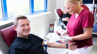R&S-Mitarbeiter Bastian Espertshuber bei seiner Blutspende durch Kerstin Englbrecht vom BRK.