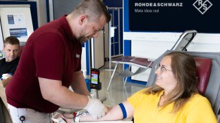 R&S-Mitarbeiterin Katrin Mühlbauer bei ihrer Blutspende durch Andreas Hofpointner vom BRK.