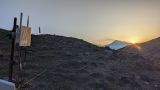 A closeup of an outdoor Wi-Fi access point in the mountains at dusk. You see the rising sun in the background. This is the analog mars mission site in Armenia in the year 2024. 